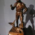 Bronze représentant un combat de coqs sous le regard d'un jeune garçon.